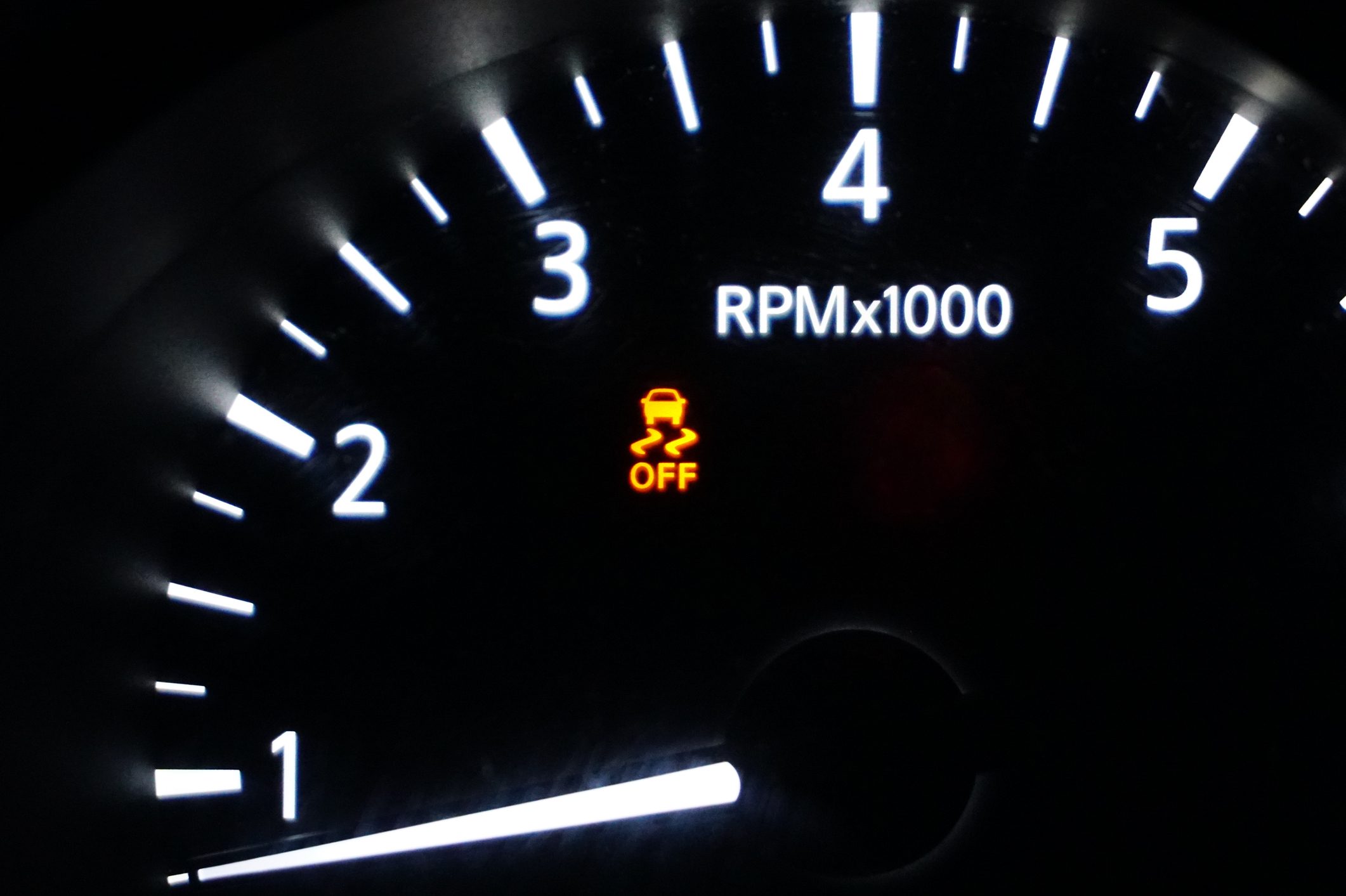 Tachometer shows RPM with lighted numbers; traction control indicator displays "OFF" beneath a car symbol, all on a dark background.