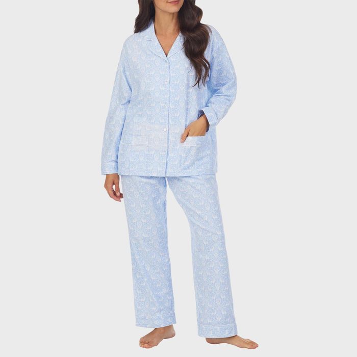 A person models light blue patterned pajamas, standing barefoot against a plain white background.