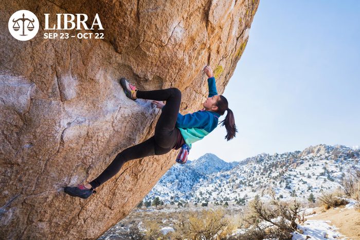 a young woman climbing a rock