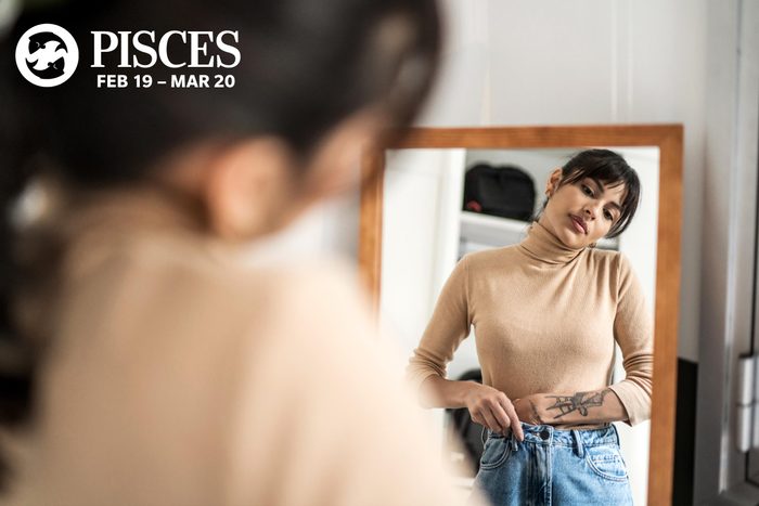woman trying on clothes and looking in the mirror