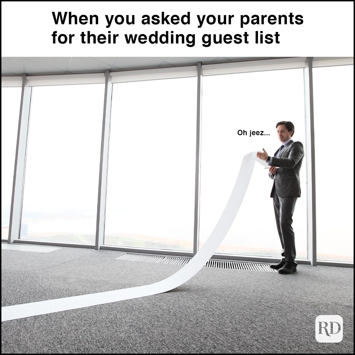 man reading very long paper roll in office