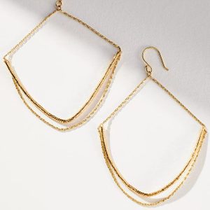 Gold wire earrings dangle elegantly, forming geometric shapes with chain embellishments, against a light, neutral background.