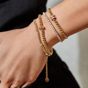 Gold and diamond bracelets adorn a wrist, displaying elegance in a stylish, minimal setting.