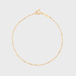 A delicate gold chain bracelet, displayed fully extended against a plain white background.