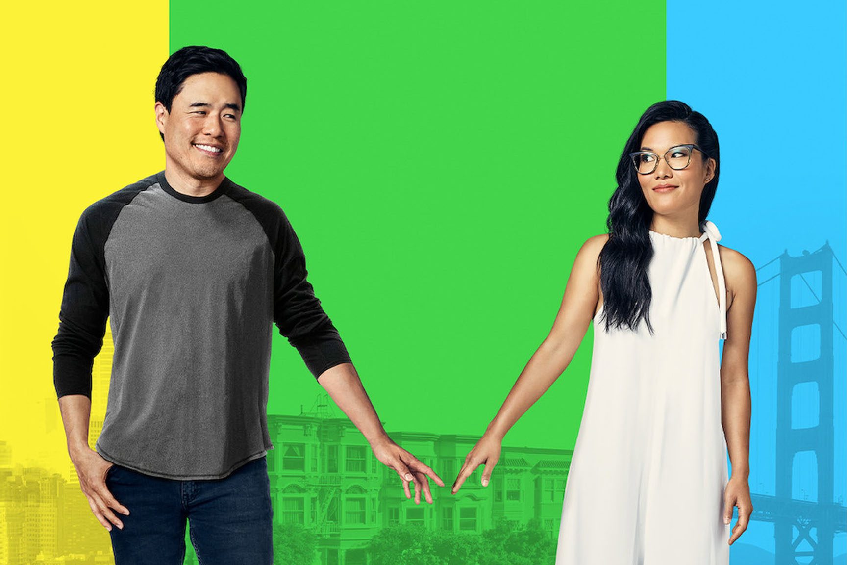 Two people face each other, reaching hands, with a colorful cityscape and partial bridge structure in the background.