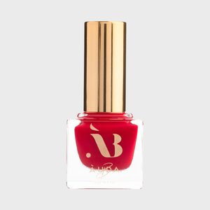 Red nail polish bottle stands upright, featuring a gold cap and a logo, against a plain gray background.