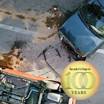 Cars are involved in a collision, debris scattered on the road. A circular badge reads, "Reader's Digest 100 YEARS."