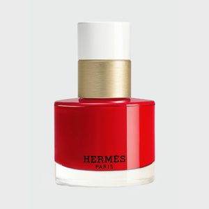 A red nail polish bottle with a gold and white cap sits against a plain background. Text reads â€œHERMÃˆS PARIS.â€