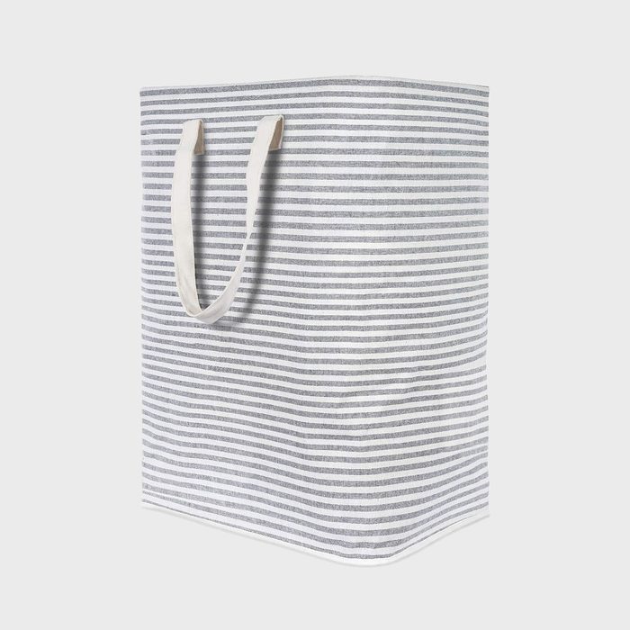 Striped fabric bag stands upright, handles extended, against a plain light gray background.