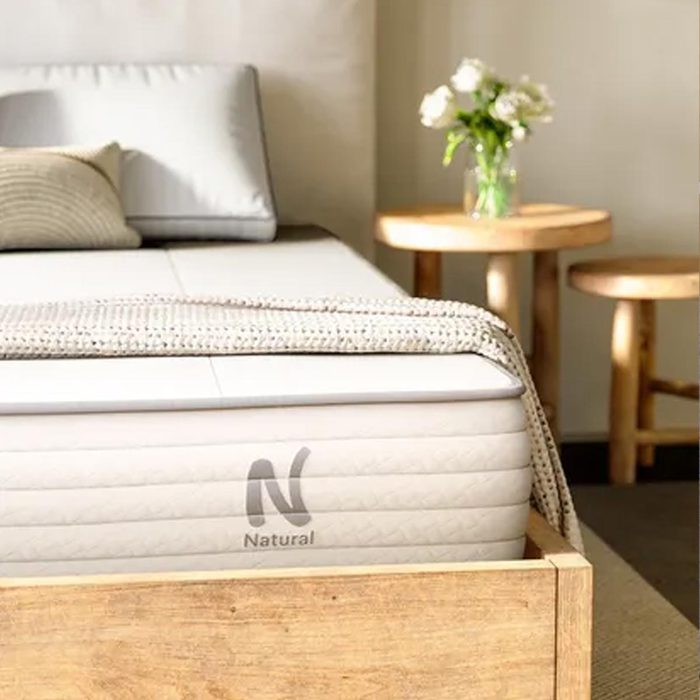 Mattress rests on wooden bed frame, with 