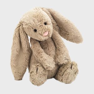 A plush bunny sits still, with long ears slightly drooping, against a plain white background.