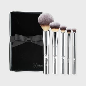 Makeup brushes stand upright alongside a shiny black case with a bow, creating an elegant display against a plain background.