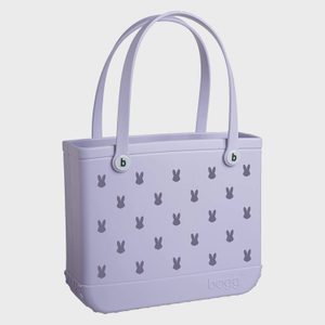Purple tote bag displays bunny silhouettes, placed against a plain, white background. The text 