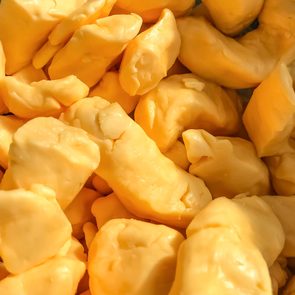 Chunks of cheese sit closely packed, displaying a smooth, bright yellow surface.