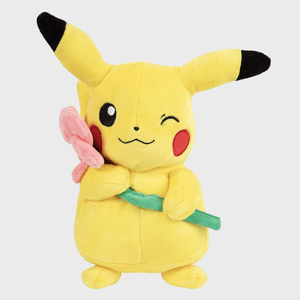 A yellow plush toy with black-tipped ears holds a pink flower, winking in a neutral background.