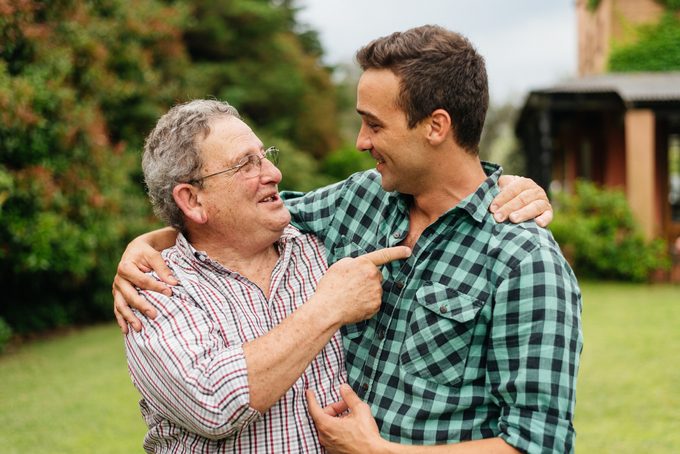 Father and adult son celebrating in their backyard