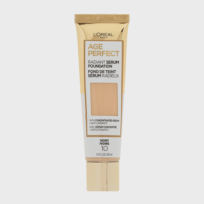 Tube displaying L'OrÃ©al Age Perfect Radiant Serum Foundation, shade Ivory 10, with antioxidants, set against a plain white background.