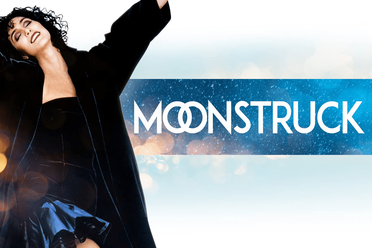 Person twirls joyfully, arms raised, in front of sparkling blue background. Text reads "MOONSTRUCK."