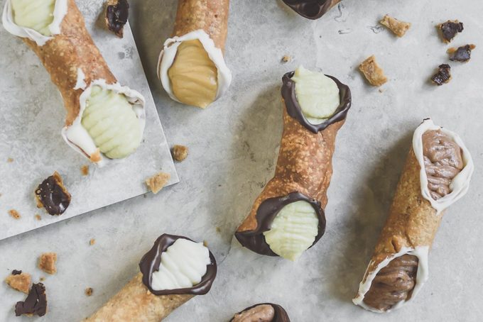 view from above of multiple cannolis on a counter with different fillings