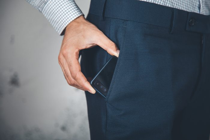 man hand phone on poket on abstract background
