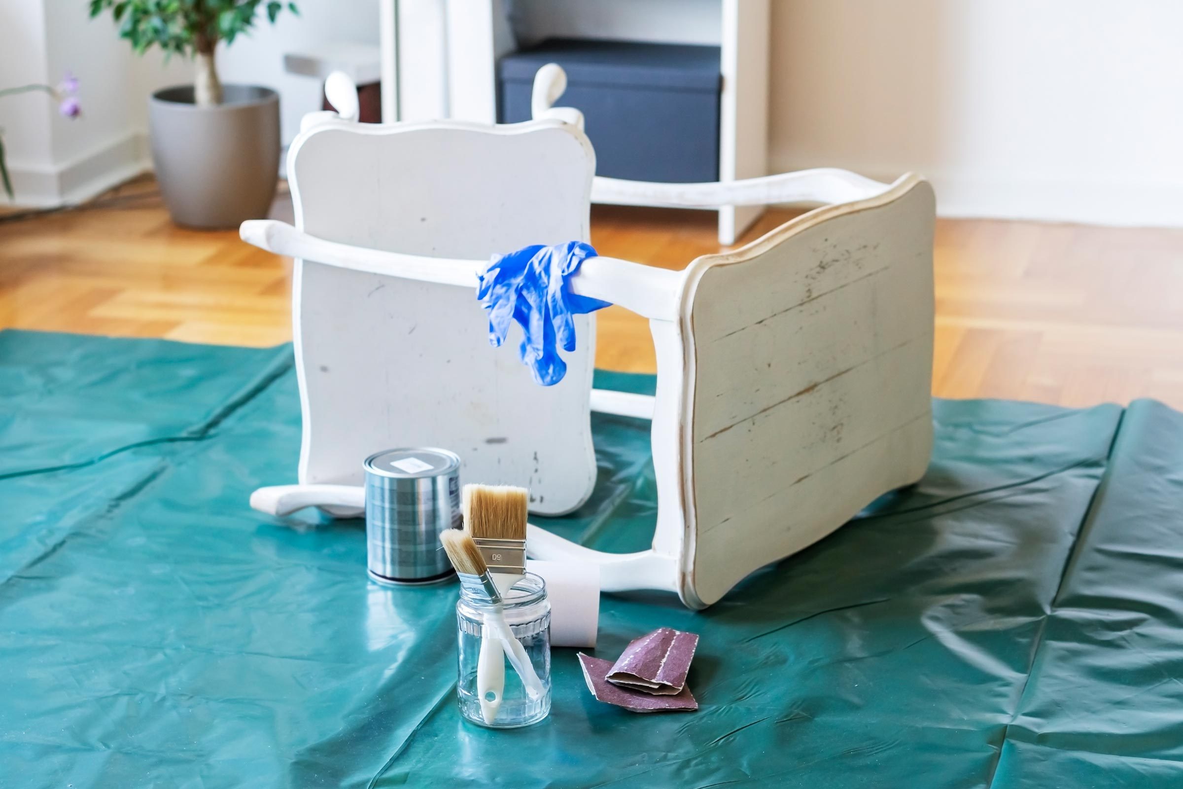 Painting an old wooden table at home to create an upcycled piece of furniture