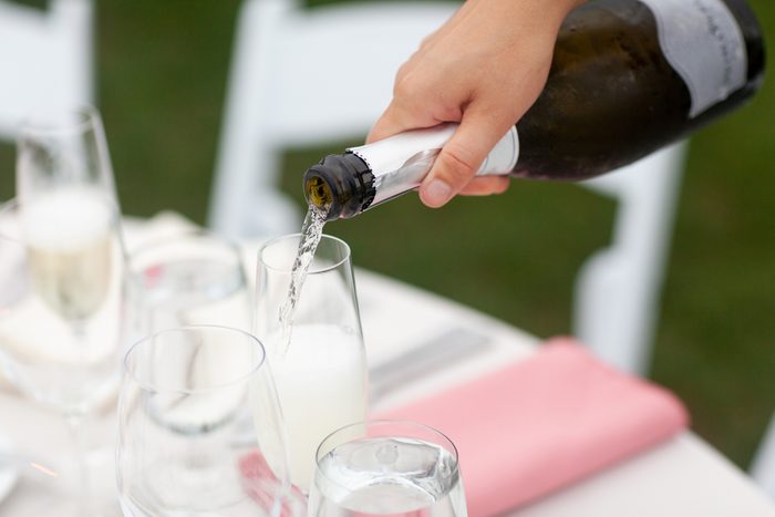 Champagne being poured into glasses at reception table