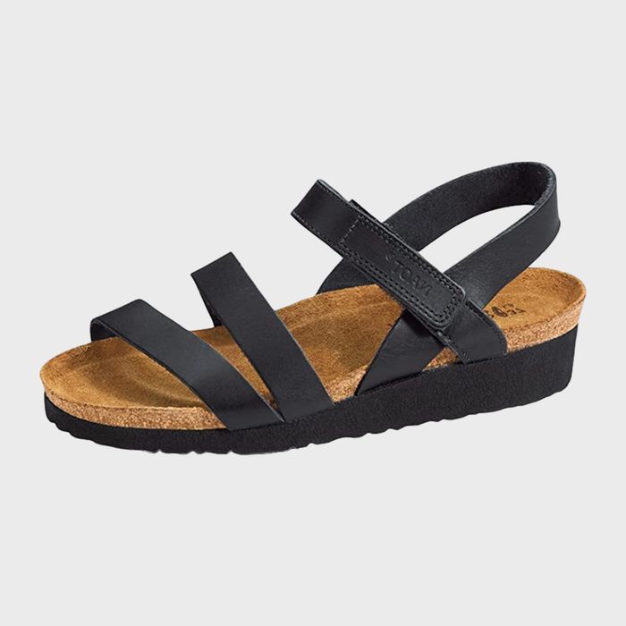 Black sandal features three straps over a cork footbed, with a thick black sole. Displayed in a studio setting, isolated on a plain background.
