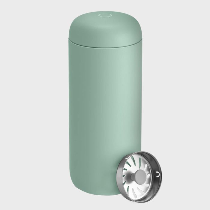 Mint green tumbler standing upright; lid rests nearby, revealing a metal strainer inside; set against a plain gray background.