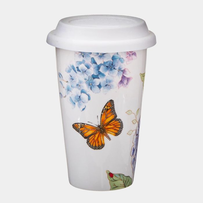 Ceramic travel mug, displaying butterfly and hydrangea illustrations, with white lid, set against a plain, white background.