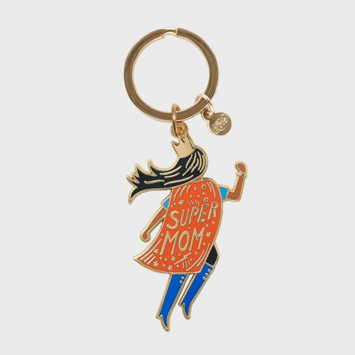 Keychain features superhero figure with flowing hair, orange cape reading 