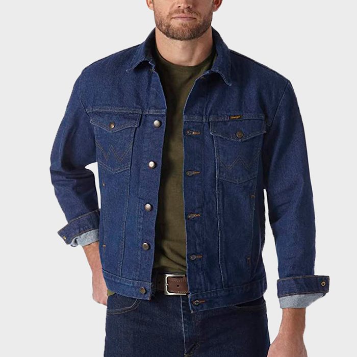 Denim jacket worn by a person, hands in pockets, against a plain light background.