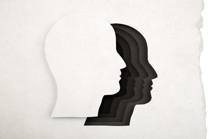 paper cut out of silhouette from white paper; in the cut out space, overlapping dark colored silhouettes