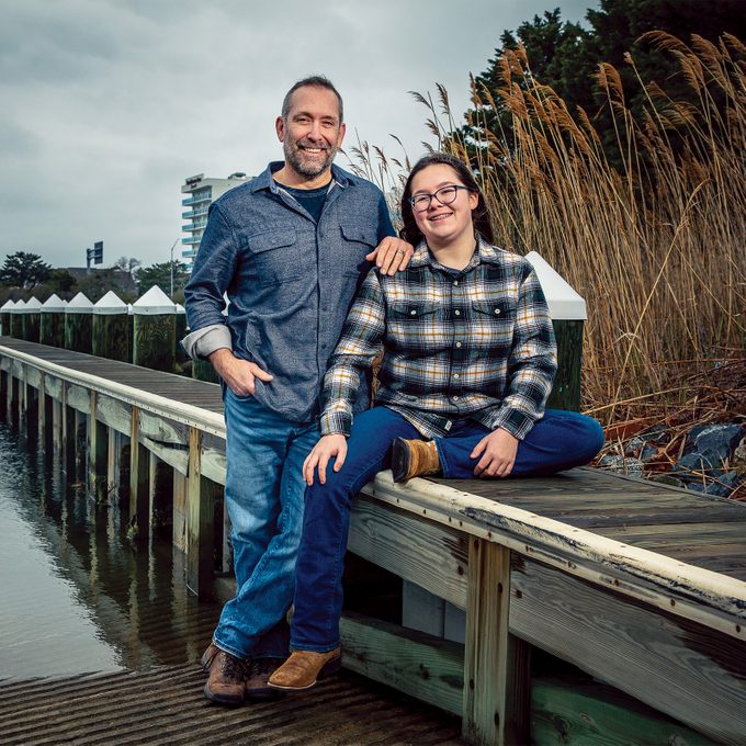 Man and daughter sitting on a pier