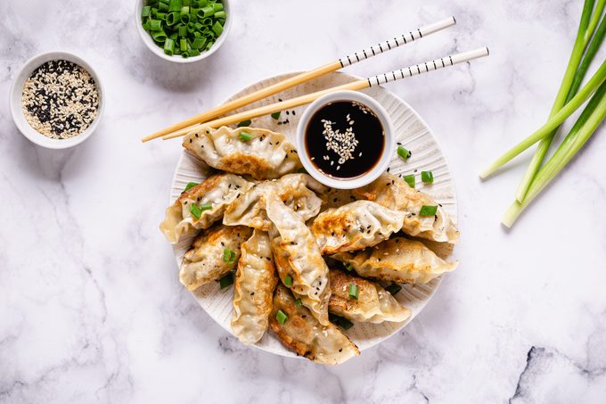 Fried dumplings gyoza with soy sauce, and chopsticks, top view