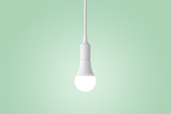Illuminated LED Light Bulb Glowing on Green