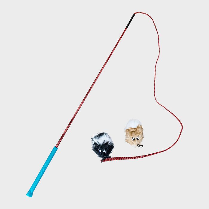 A toy wand with a blue handle and red string, featuring two furry animal attachments, lies on a plain background.
