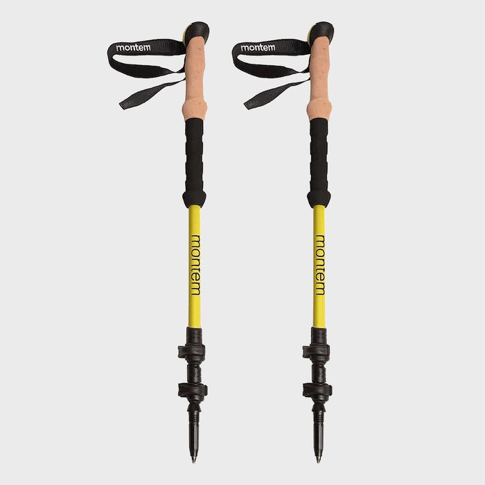 Two yellow trekking poles stand upright, displaying black grips and adjustable loops, labeled 