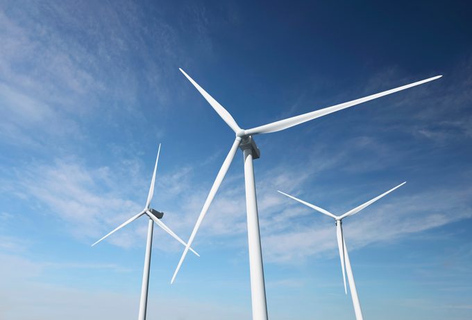 Wind turbines against an almost clear blue sky
