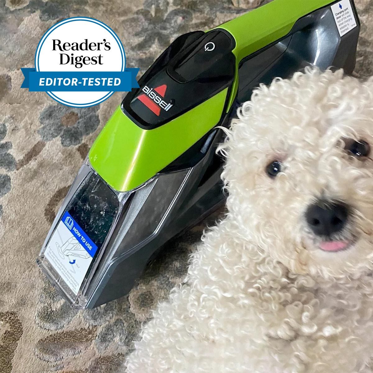 Vacuum cleaner resting on a patterned carpet beside a fluffy white dog. A badge reads "Readerâ€™s Digest Editor-Tested."