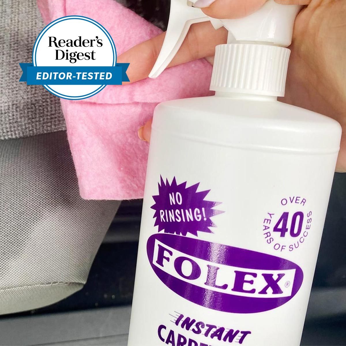 Spray bottle held; hand cleans with pink cloth; Reader's Digest badge on textured surface with visible "FOLEX" brand and "No Rinsing!" message.