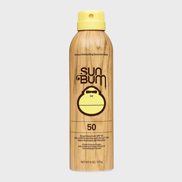 Spray can with wooden texture dispenses sunscreen in bright, minimalistic packaging. Text reads 
