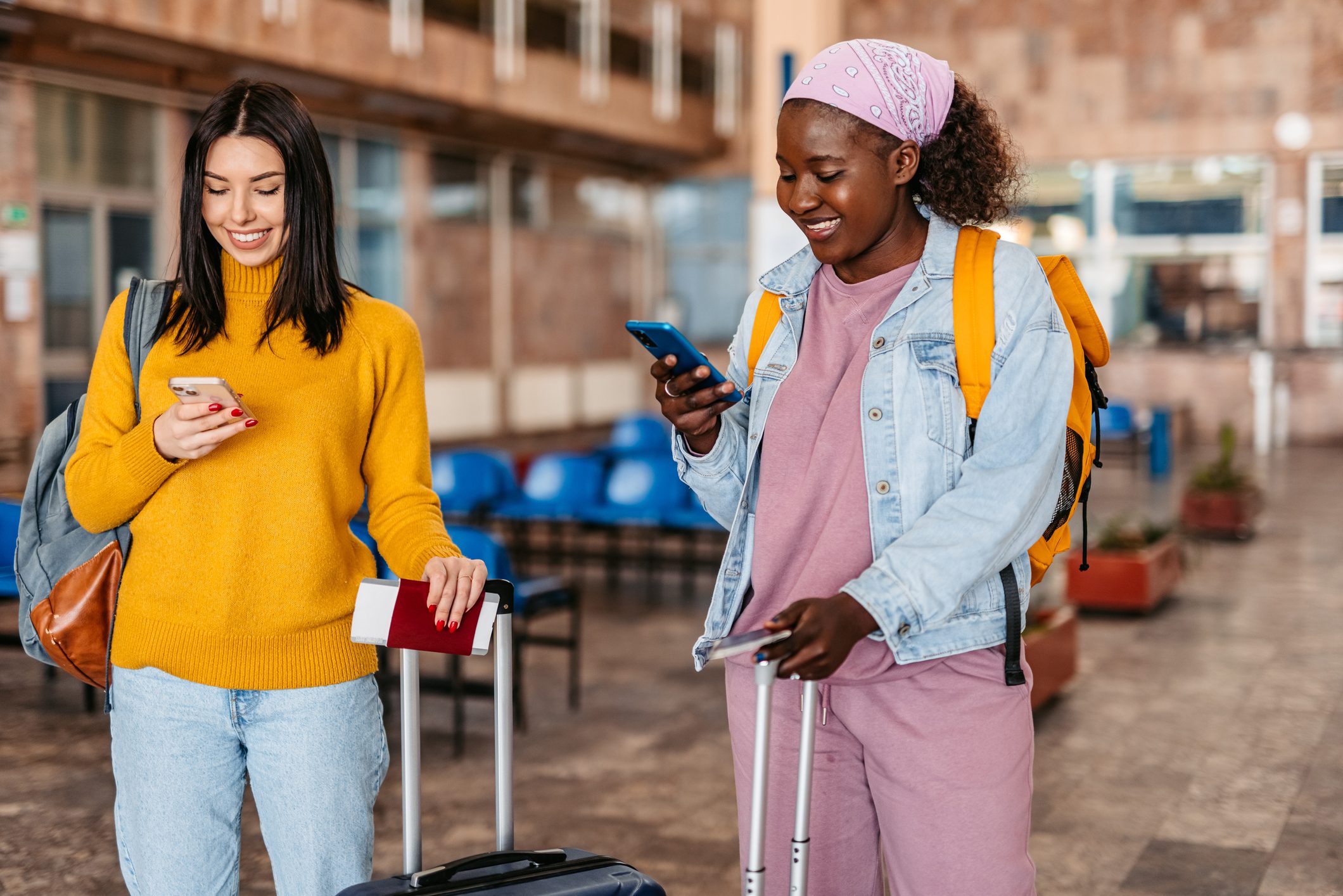 Two Young Tourists Scrolling Through Social Media At The Station
