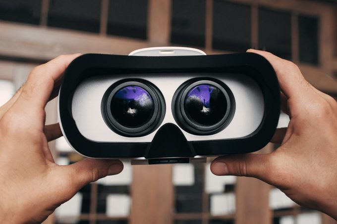 hands holding up Virtual reality glasses with image inside