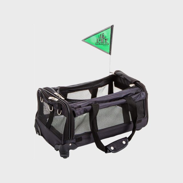 Rolling pet carrier sits on the ground, featuring mesh sides and top zippers, with a small green flag labeled 