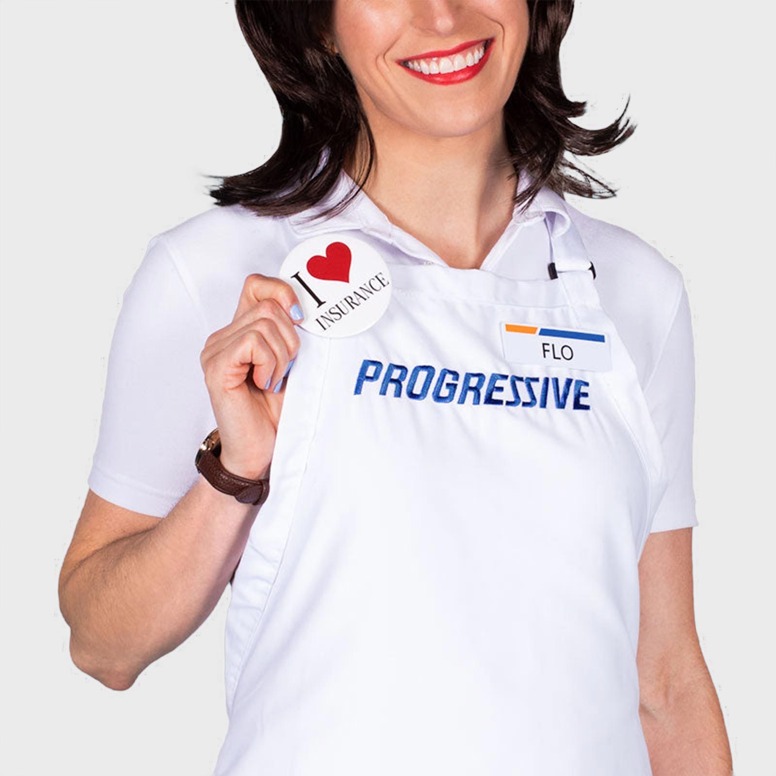 Person holds button reading "I &acirc;&curren;&iuml;&cedil; INSURANCE," wearing white apron labeled "PROGRESSIVE" and name tag "FLO," smiling against plain background.