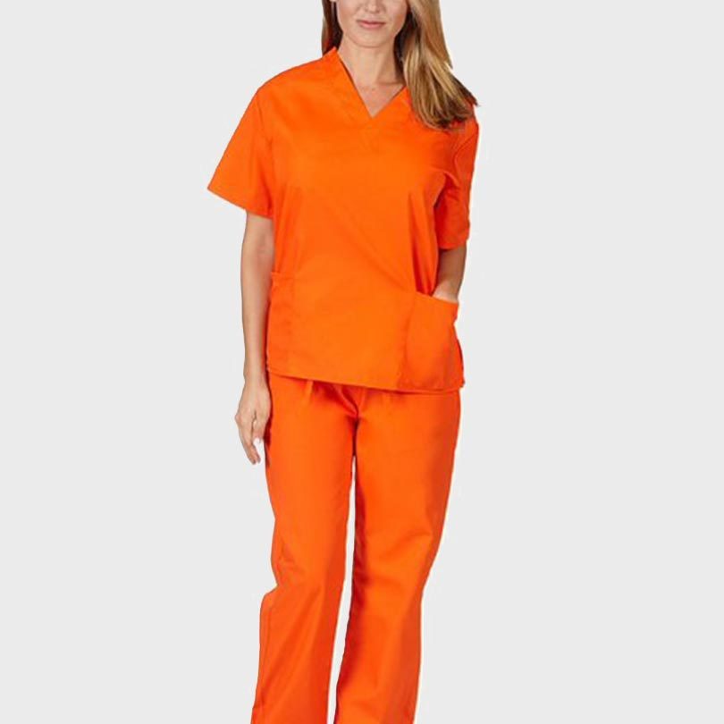 Person wearing bright orange scrubs stands against a plain, light background.