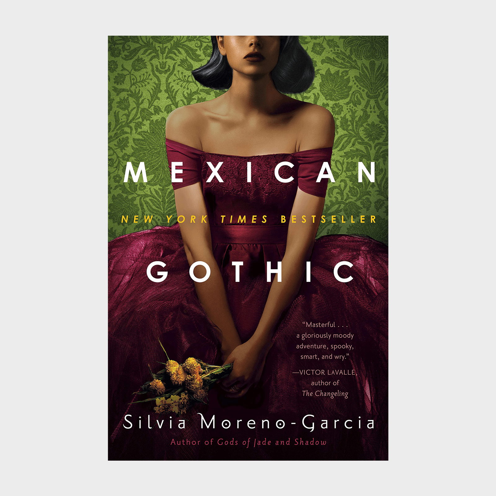 A woman in a burgundy dress holds flowers against a green patterned background. Text: "Mexican Gothic" by Silvia Moreno-Garcia, "New York Times Bestseller."