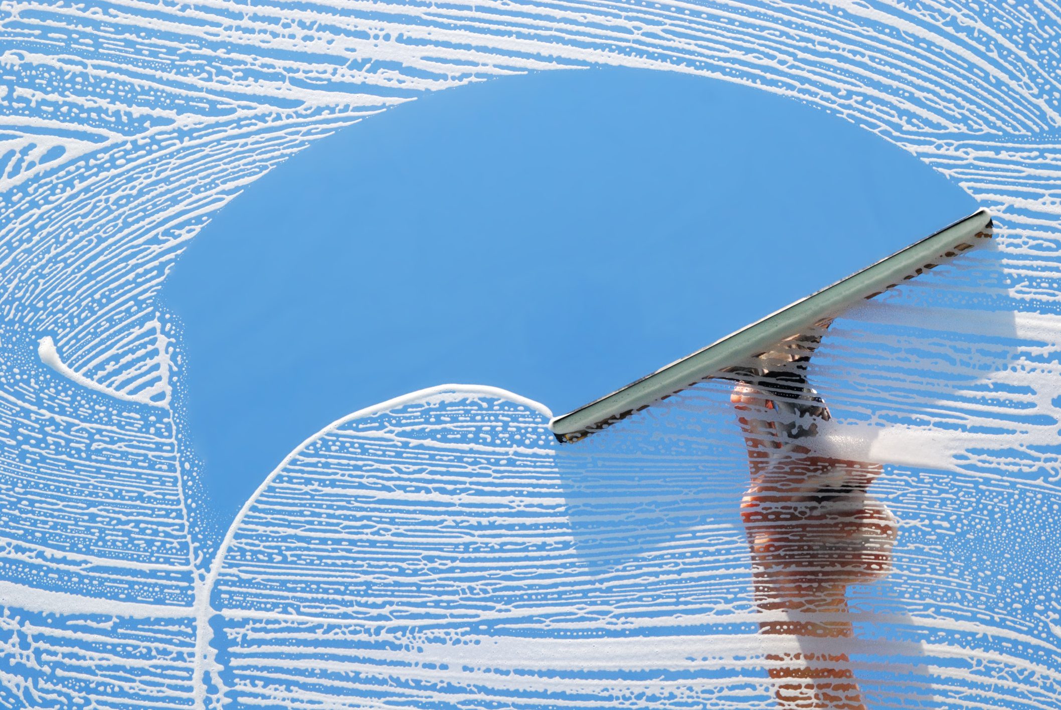 Cleaning and washing a window with a squeegee.