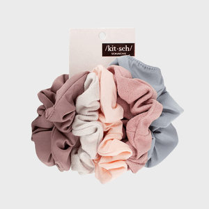 Scrunchies are displayed bundled together on packaging, showcasing soft pastel colors. The label reads â€œ/kitÂ·sch/ SCRUNCHIEâ€ in a minimalist style against a white background.
