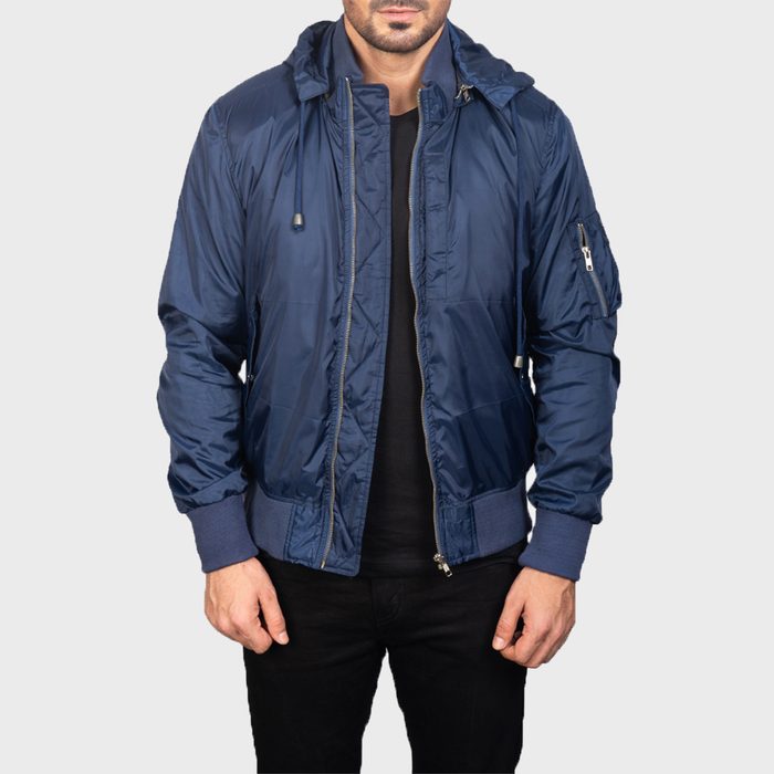 Person wearing a blue hooded jacket with a zipper, hands relaxed, against a light gray background.